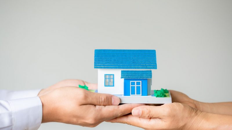 Real estate broker agent presenting and consult to customer to d Real estate broker agent presenting and consult to customer to decision making sign insurance form agreement, home model, concerning mortgage loan offer for and house insurance.